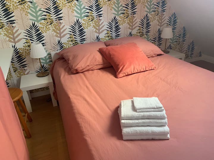 Spavaća soba s krevetom od 140 cm i malim ormarom.