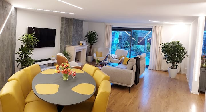 velikodušan prostor s kaminom, velikim Smart TV-om Netflix, modernim led svjetiljkama koje mogu promijeniti intenzitet i boju, jednostavnim kliznim vratima koja vode do vrta punog cvijeća