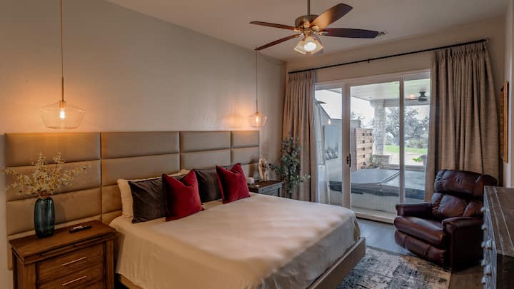 O quarto principal com colchão Tempurpedic, roupa de cama macia, TV de 55", mesas de canto com portas USB, vista para a região montanhosa e uma banheira de hidromassagem bem na sua porta.