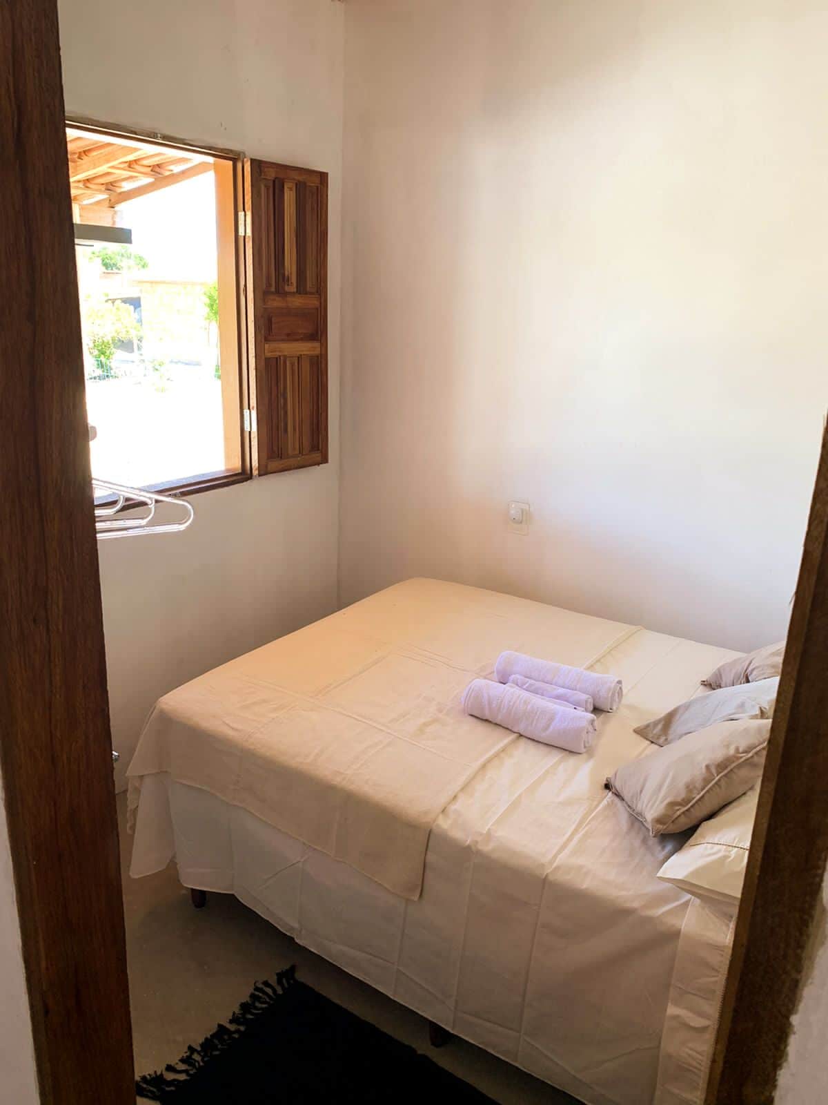 חדר שינה 1 - עם מיטה זוגית, מאוורר, מתלה בגדים ומדפים כדי להכיל מזוודות.