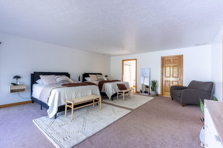 dormitorio principal en la planta superior con dos camas tamaño queen y un baño adjunto. 