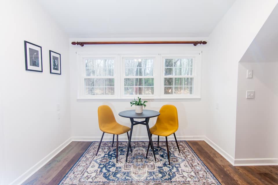 Dining nook with two yellow chairs by the window
