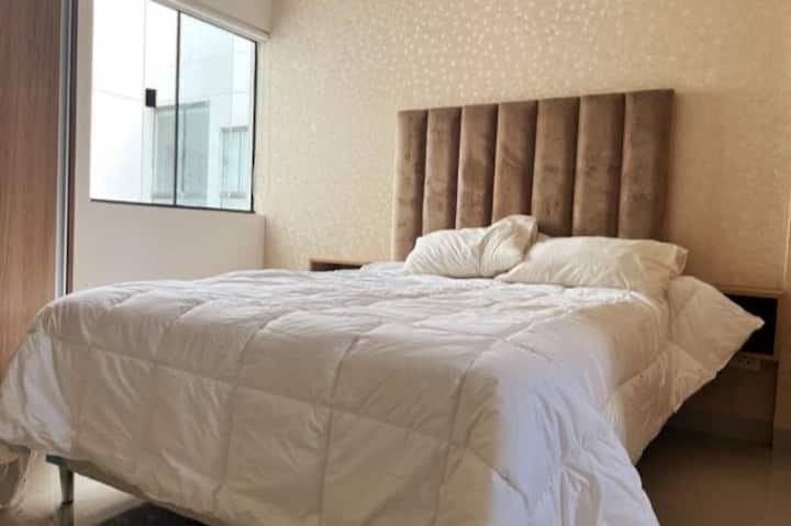 Vista frontal del dormitorio donde se ve la cama de dos plazas.