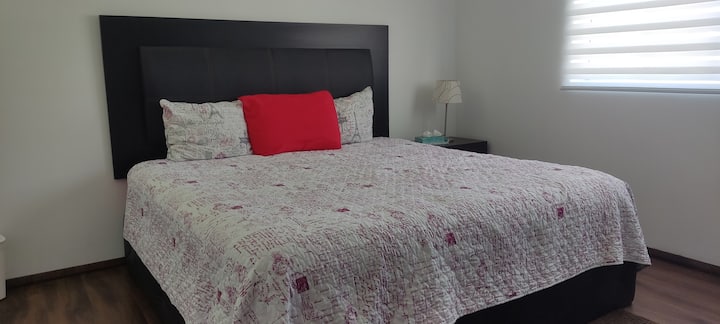 غرفة نوم تحتوي على سرير من كالكينغ ومكيف هواء وتلفزيون ذكي