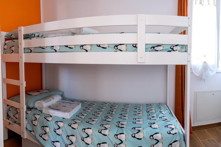 Chambre charmante avec lit superposé, idéale pour les plus jeunes ou pour des aventures en famille. Les étagères offrent un espace pour les vêtements et le climatiseur maintient la température parfaite.