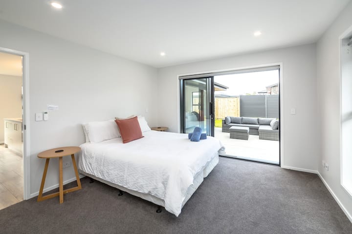 Un espacioso dormitorio principal con una lujosa cama tamaño king con ropa de cama premium.