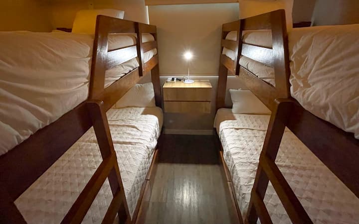 - Dos literas, una de ellas es una cama doble (arriba y abajo) y la otra es una cama individual (arriba y abajo). 
-Hemos decorado cada cama con luces.
- Hay cajones muy amplios, una mesa de noche con cajones y diferentes puntos para cargar teléfonos celulares.