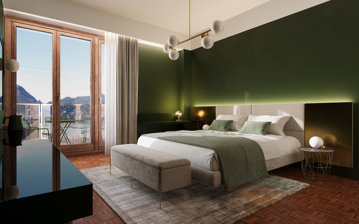 A spacious bedroom features dark green walls and large windows offering views of the surrounding landscape. A comfortable bed is centered in the room, accompanied by a stylish bench and decorative nightstands. Soft lighting from overhead fixtures enhances the tranquil environment.