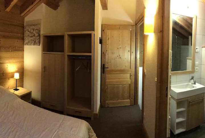 Zoom de espaldas a la puerta de la ventana de la parte superior: a la derecha, la SDB-WC privada, frente a los 2 armarios y la puerta de entrada. Detrás de la puerta, la zona de montaña (enfrente) y la escalera de acceso a la planta baja (a la derecha)