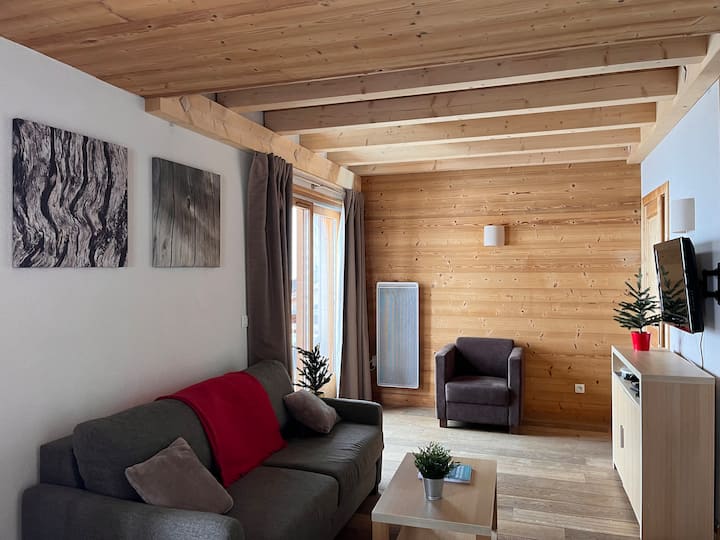 Zona de estar con sofá cama y sillón, TV y ventanal que permite acceder a la terraza a lo largo (puerta de acceso al vestíbulo de entrada a la derecha). La escalera interior de acceso a los pisos inferior y superior a la derecha. Suelo de parquet.