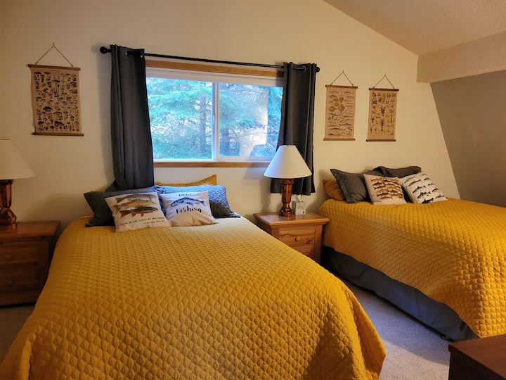 Spálňa na poschodí s dvoma manželskými posteľami.