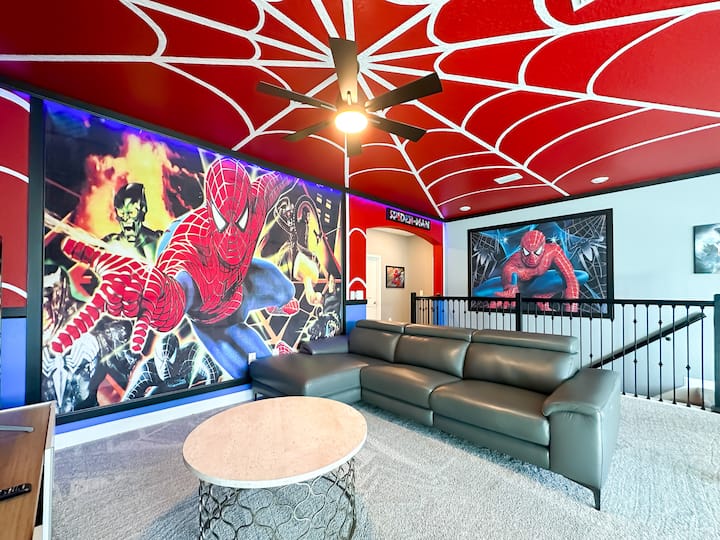 Започнете дейността си в този лофт с тематика на Спайдърмен! Драматичен таван с паяжина се извива над главата, а ярката стенна стенопис показва Спайдърмен в разгара на действието. Отпуснете се на елегантния кожен диван, завъртете вентилатора и оставете светлината на LED таблото
