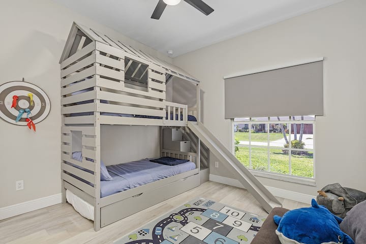 Twin bunk room with a playful vibe, trundle bed and children’s sofa – a dream space for younger guests.