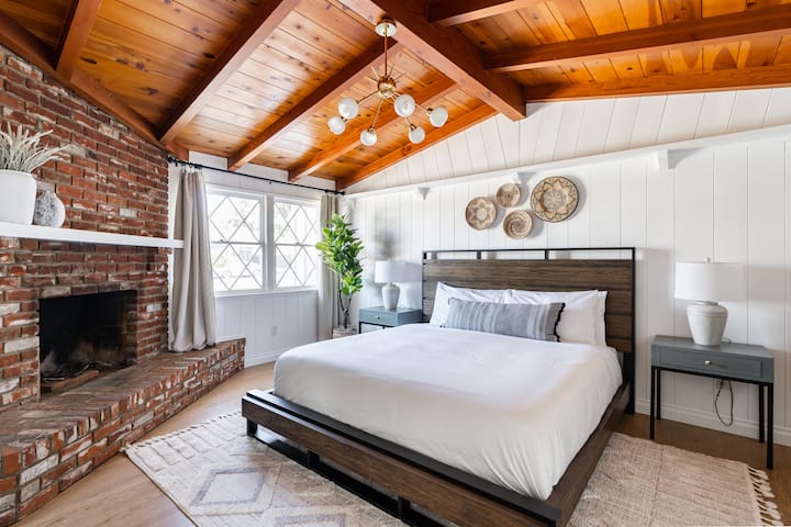 ห้องนอนหลักมีเตียงคิงไซส์ที่สะดวกสบายเพดานห้องนิรภัยและเตาผิง