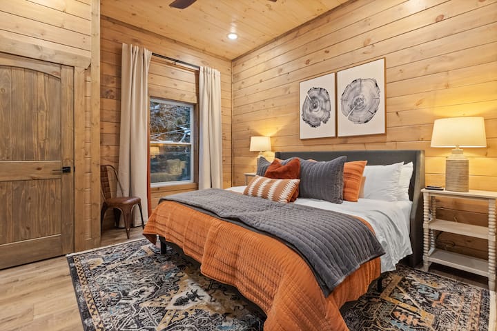 غرفة نوم أساسية في الطابق السفلي مع تلفزيون ذكي.