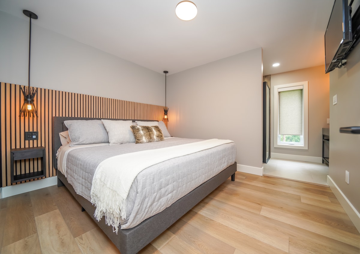 当您进入主卧时，您会看到干净的线条、天然材料和宁静感。 套房配有双水槽、玻璃淋浴间和独立卫生间。