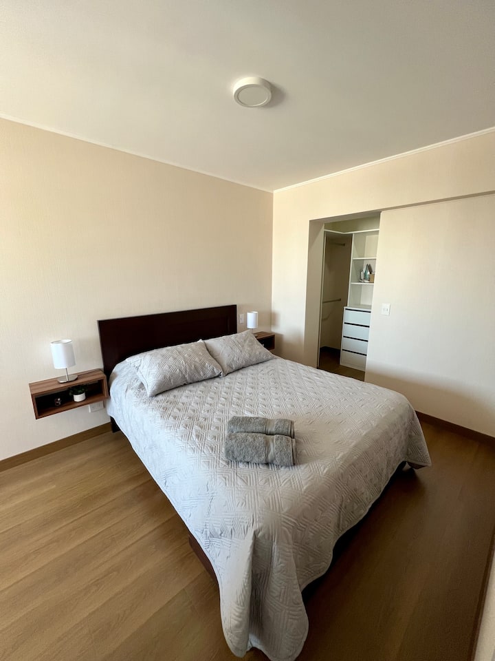 Просторна и добре осветена основна стая, оборудвана с двойно легло и нощна маса с лампи за четене.