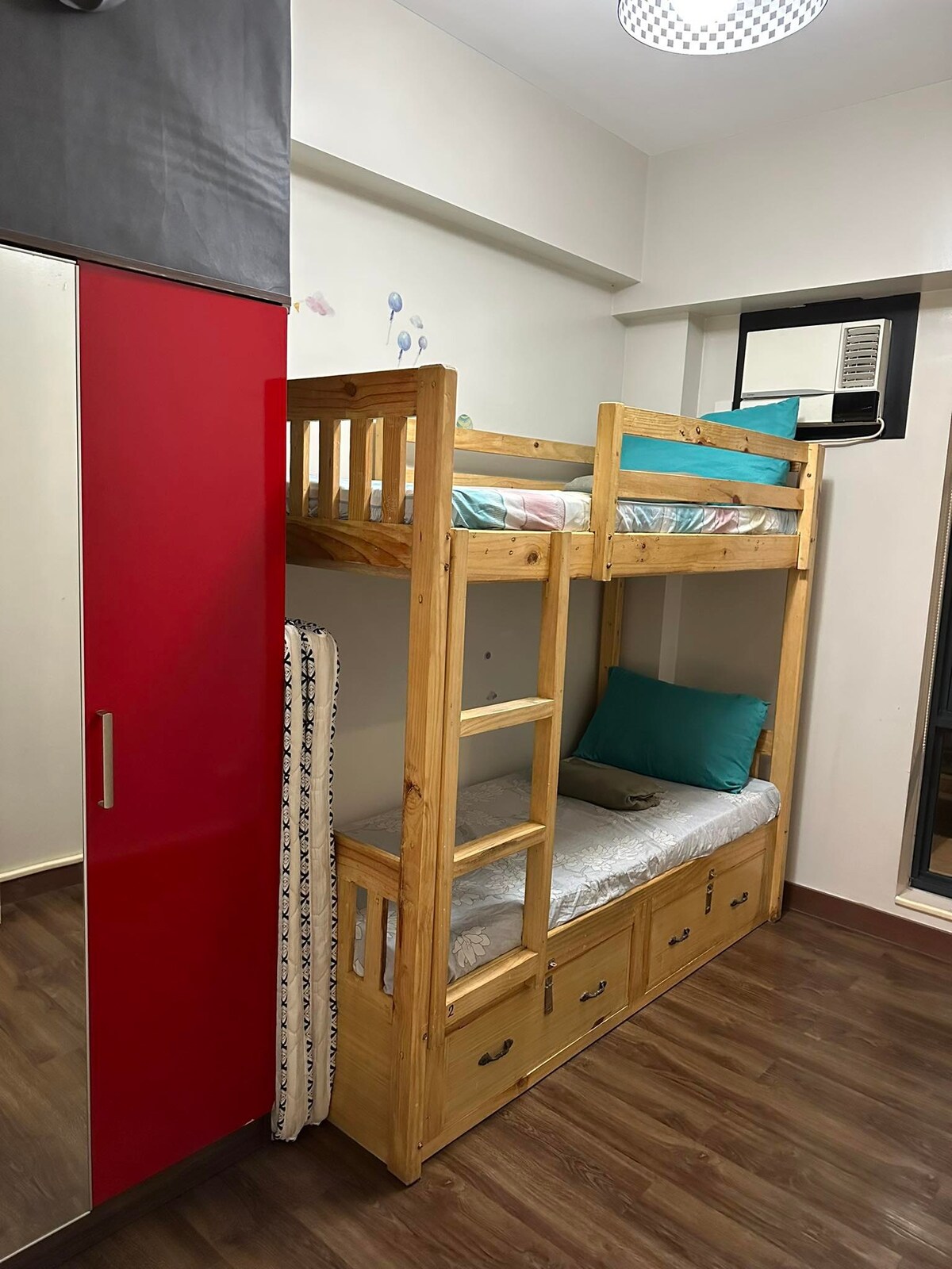 חדר קטן עם מיטת קומתיים ושני מזרנים נוספים על הרצפה