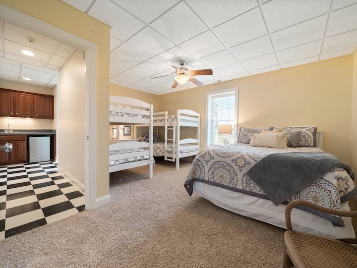 Camera gialla all'alba con un letto matrimoniale e due set di letti a castello