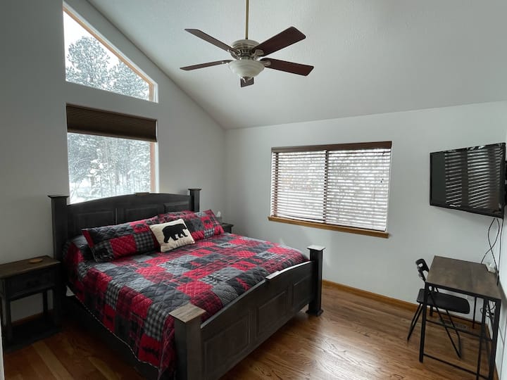 Chambre king size principale au niveau supérieur avec bureau, télévision HD, ventilateur de plafond et plafonds voûtés.