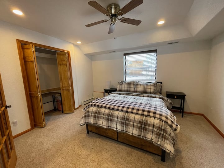 Grande chambre avec lit Queen Size avec bureau, grand dressing et vue sur la forêt.