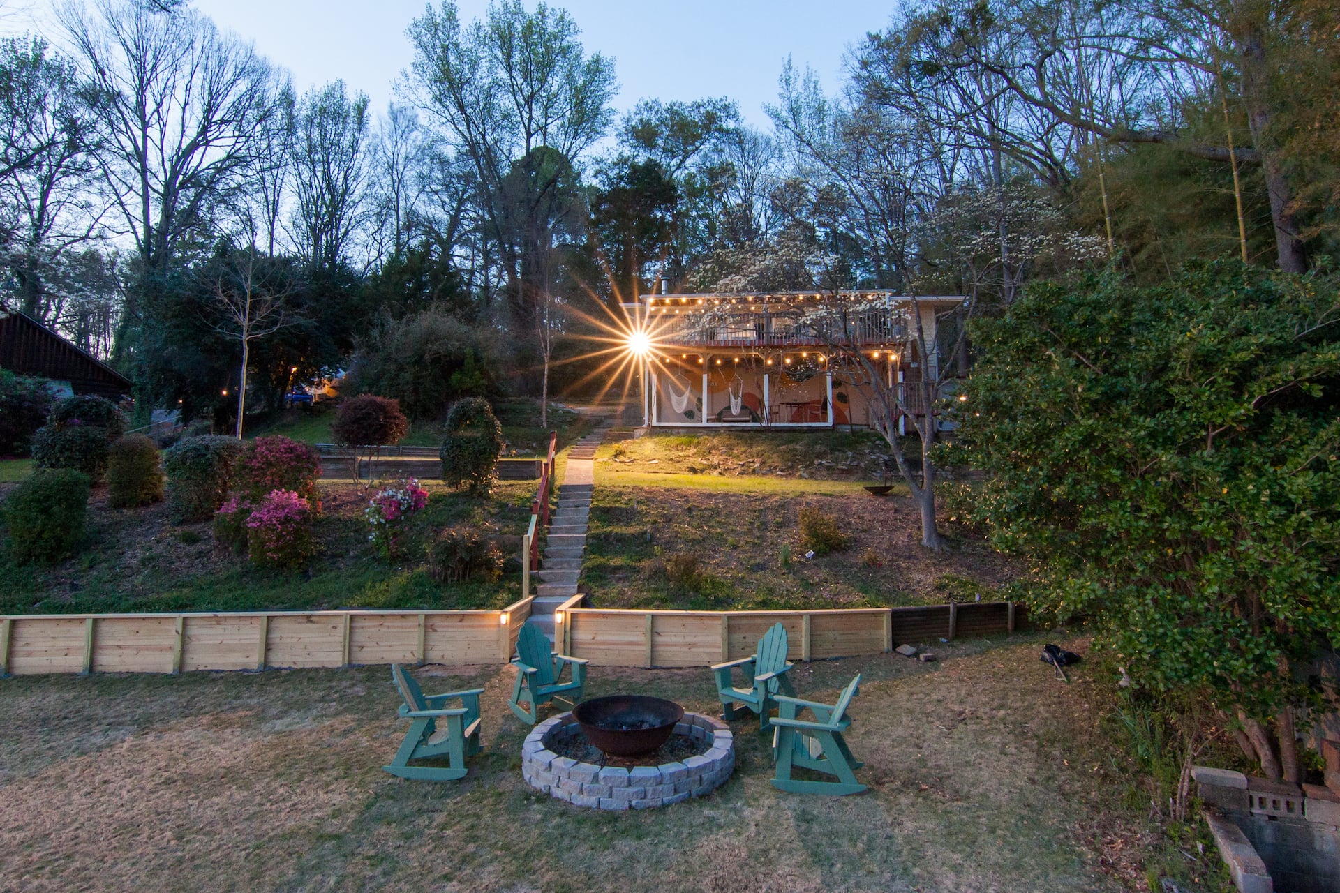 Backyard fire pit with Adirondack chairs lit at night