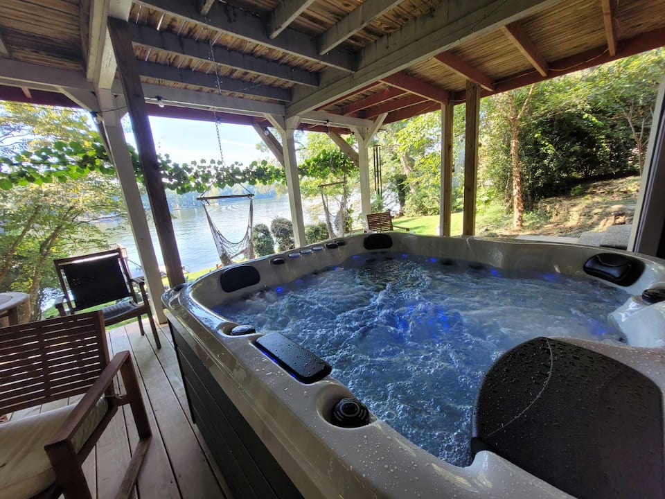 Hot tub on the deck with the lake behind it