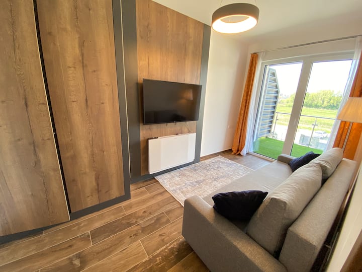 Помалата спална соба со кауч на извлекување. Оттука може да стигнете и до терасата. Ладење/греење со систем за намотување на вентилаторот.