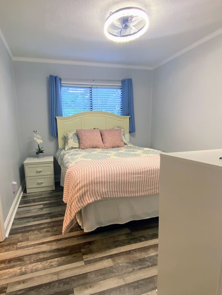 Dormitorio principal con cama tamaño queen, dos mesitas de noche, puertos USB, vestidor y armario.