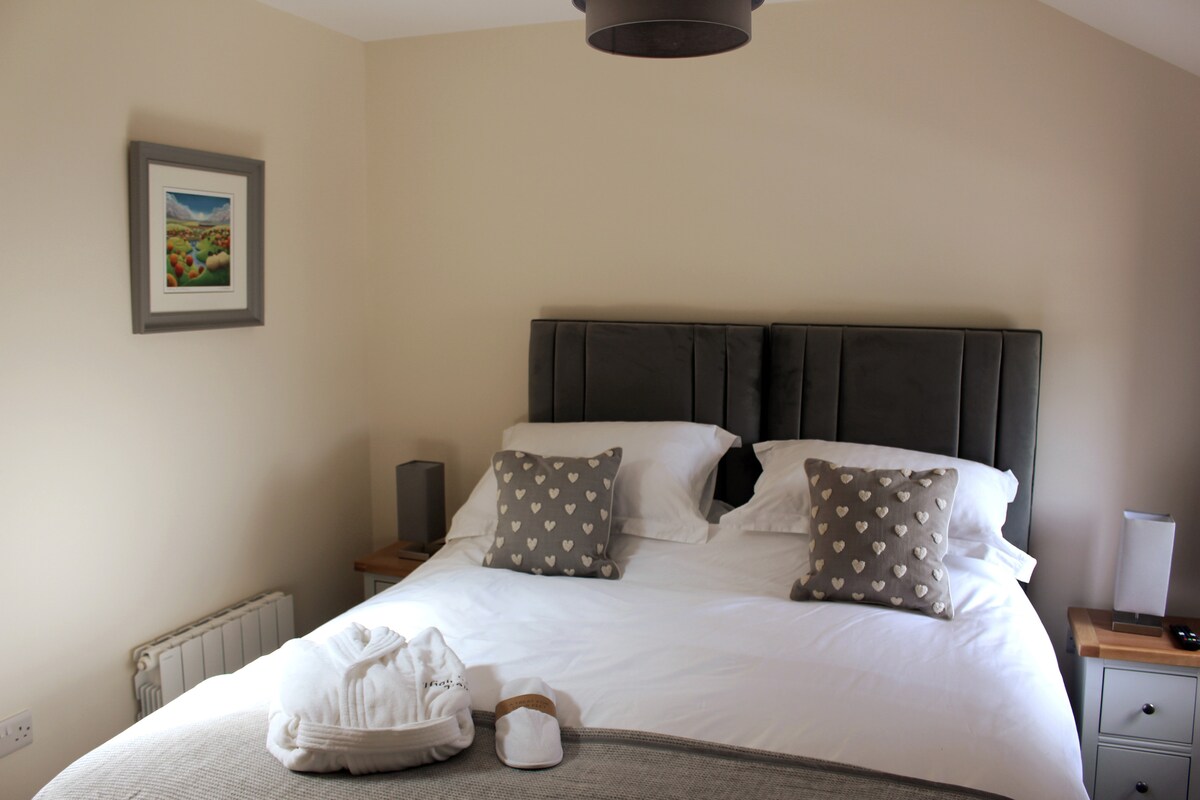 Dormitorio 2 con baño privado, bañera de hidromasaje y ducha. La cama tamaño king se puede convertir en dos individuales.  Televisión inteligente. Armario espejado y amplio almacenamiento.