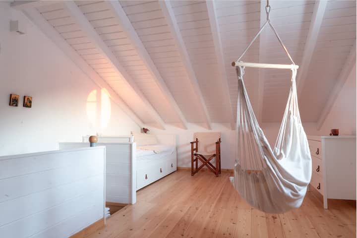 Upper bedroom with hanging chair and 2 large single beds.