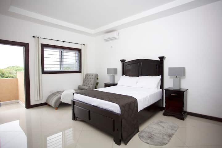 Ფართო ძირითადი საძინებელი, გორაკის ხედი, კარადა მარცხნივ კომოდის კარადით, კონდიციონერი, კედლის დიდი სარკე