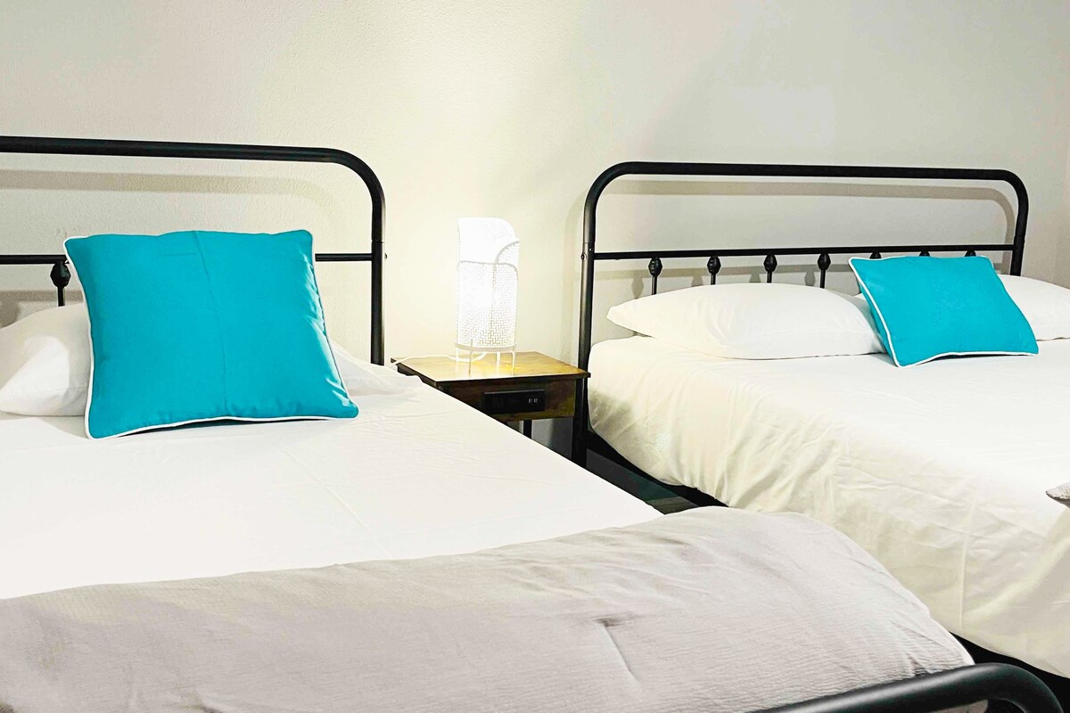 Habitación espaciosa con una cama tamaño queen y una cama individual