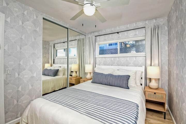 Acogedora cama tamaño queen con ventilador de techo y sábanas lujosas 