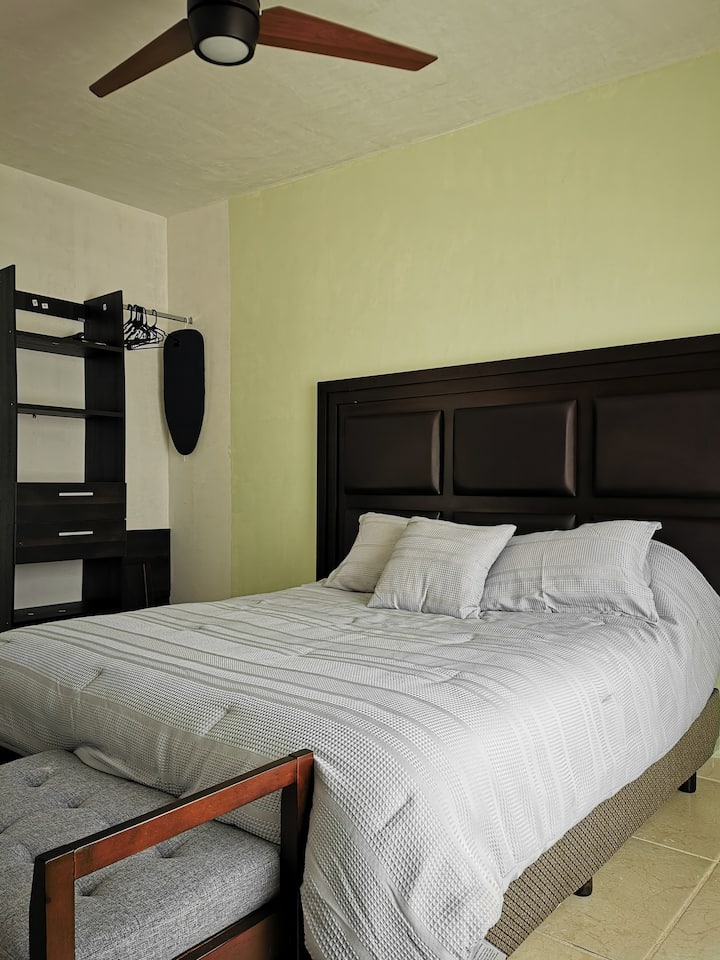 חדר ראשי עם מיטת קווין סייז, ארון, מאוורר תקרה, מאוורר מגדל, פריו / חימום קטן ואמבטיה מלאה.