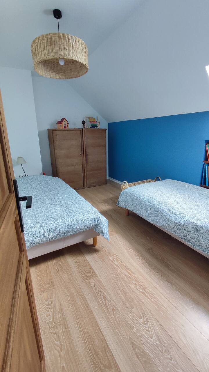 Une des chambres de l'étage avec deux lits simples et des jouets