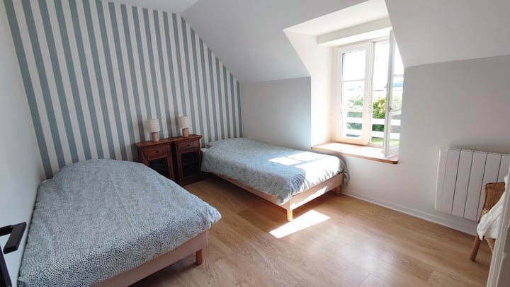 une des chambres de l'étage avec deux lits simples et vue sur la cour