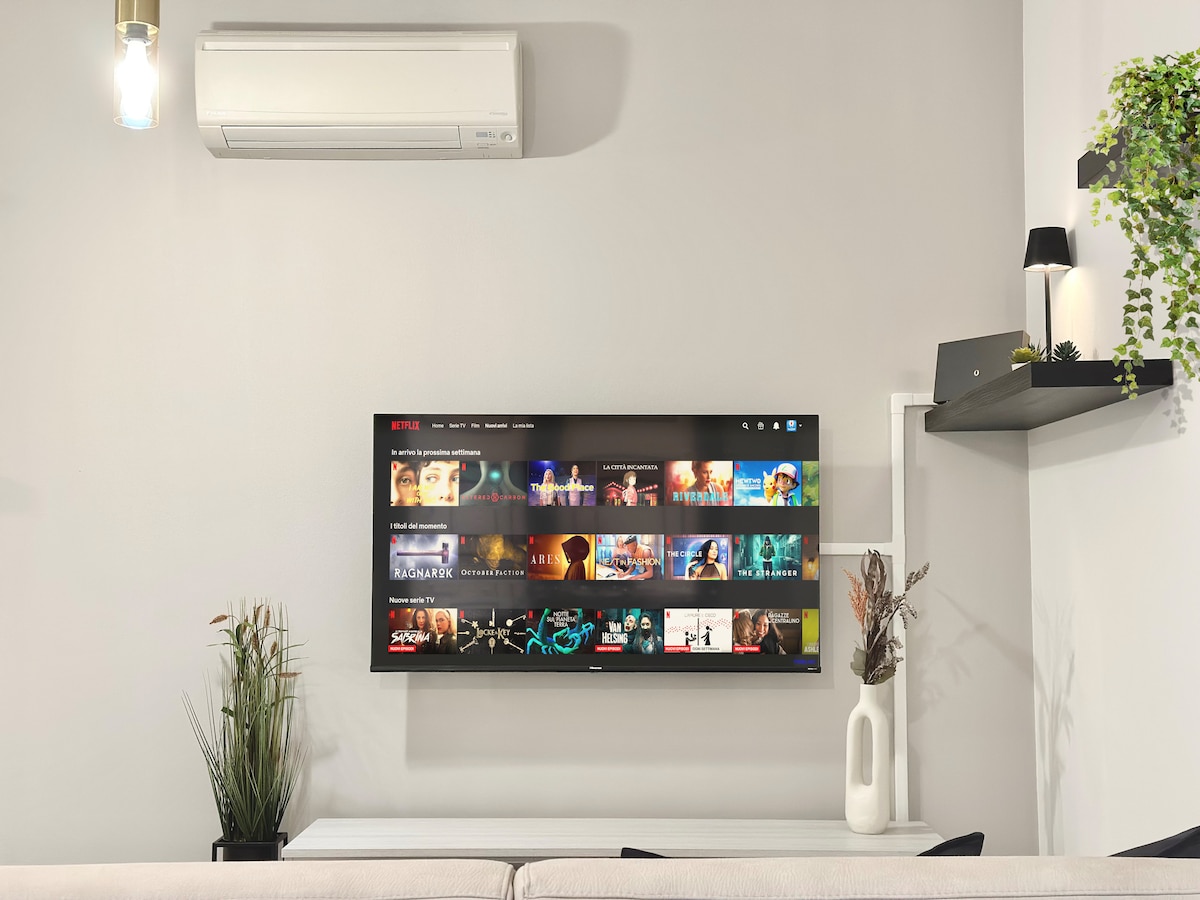 Sala de estar con gran televisor inteligente de 50 pulgadas, wifi, aire acondicionado, aire acondicionado y sofá cama.