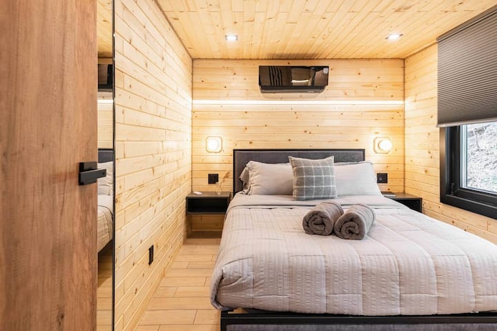 Con una gran ventana que proporciona luz natural, este dormitorio tamaño queen ofrece un ambiente cálido y acogedor y privacidad, ideal para una mañana relajante.