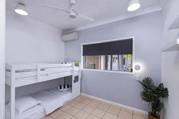 Bunk beds with split system air conditioning, ceiling fan and TV.