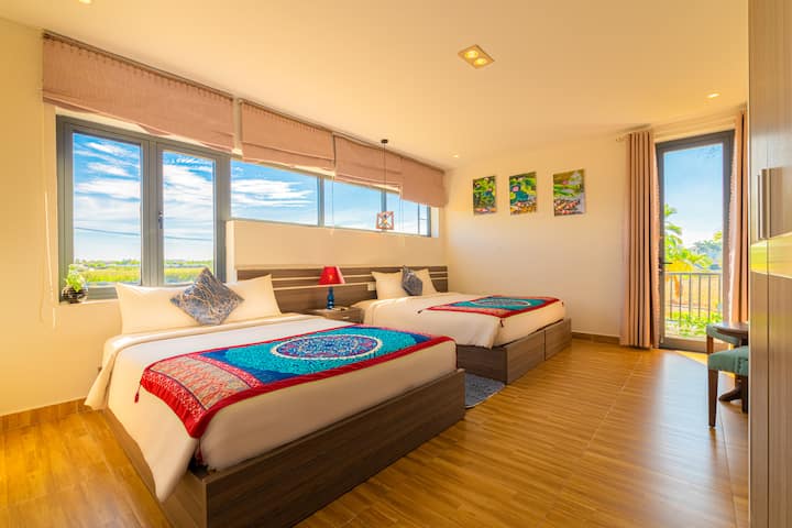 CHUMBA CHA BLUU:
Chumba cha kulala chenye kitanda kimoja cha watu wawili na vitanda viwili vya mtu mmoja vinaweza kugeuzwa kuwa kitanda kingine cha watu wawili kikamilifu kwa ajili ya chumba cha familia.
Unaweza kuangalia juu ya shamba la mchele kutoka kwenye chumba hiki. Balcony na kiti cha sofa.