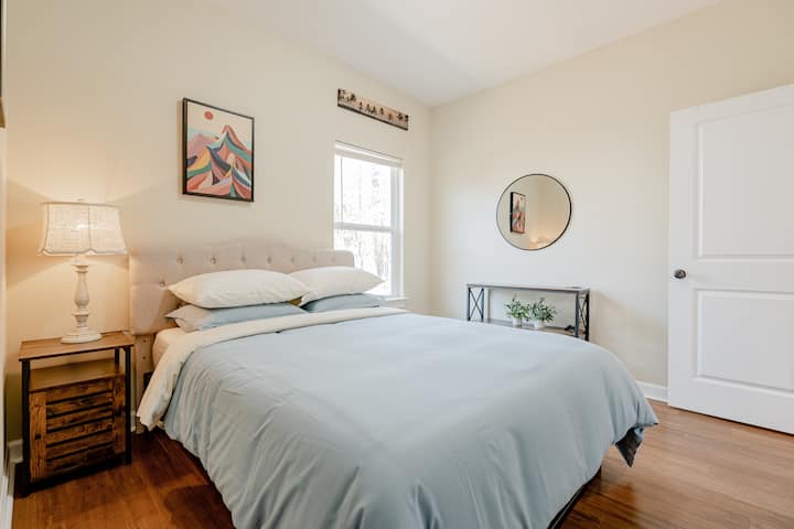 La chambre bleue/une petite chambre d'hôtes - avec table console avec miroir rond, stand de nuit et art mural rendent la chambre confortable et fonctionnelle. 