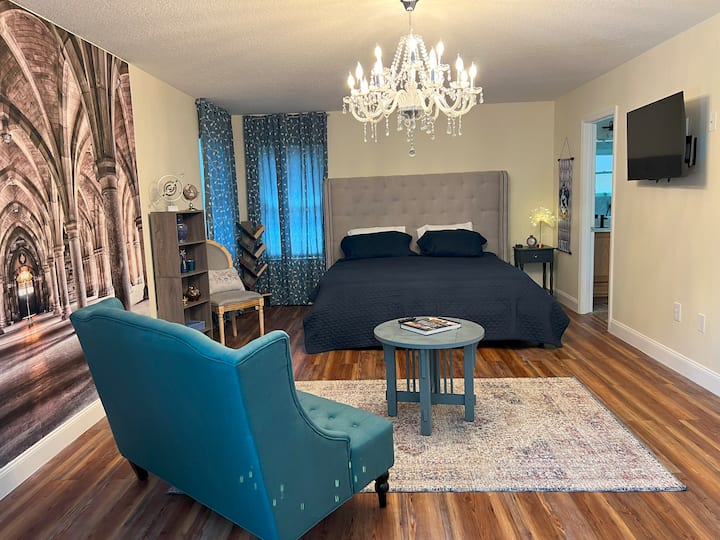 تحتوي غرفة النوم المستوحاة من Ravenclaw على بعض الميزات المرتفعة والمريحة مثل إطار سرير كينج مخصص وأريكة ومكتب/تزيين وكتب سلسلة هاري بوتر وجدارية جميلة للاستمتاع بها!