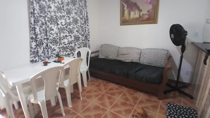 Obývacia izba so štvormiestnym obdĺžnikovým stolom a rozkladacou pohovkou, plus 32-palcová televízia