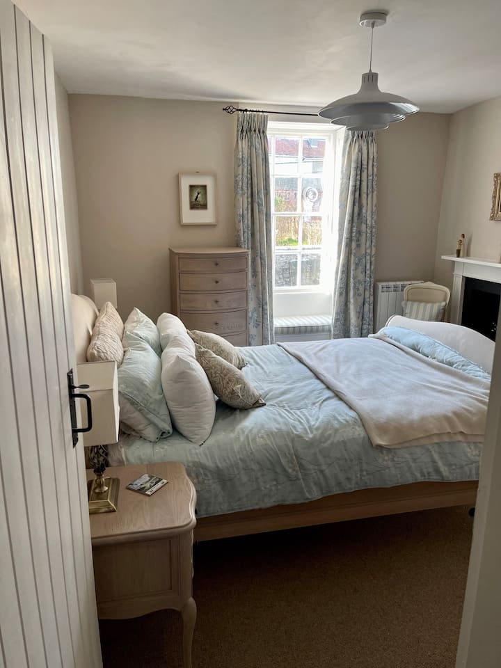 First floor bedroom with king size bed, wardrobe, tallboy, bedside cabinets and lamps. Original windows and shutters, window seat. Ornate original fireplace (non working). New Rointe radiator 