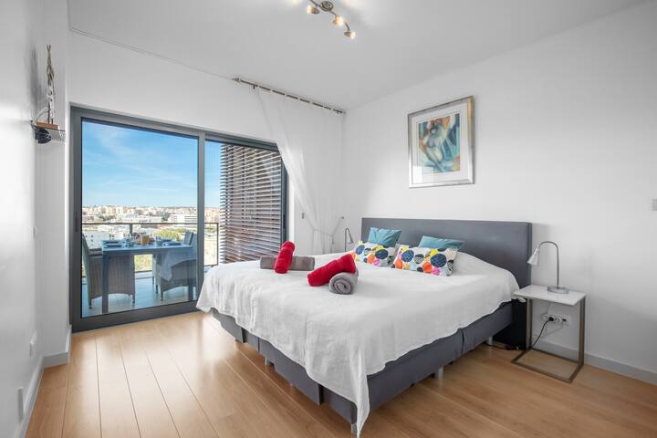 غرفة نوم داخلية بسرير بمقاس كبير وإمكانية الوصول المباشر إلى الشرفة الكبيرة 