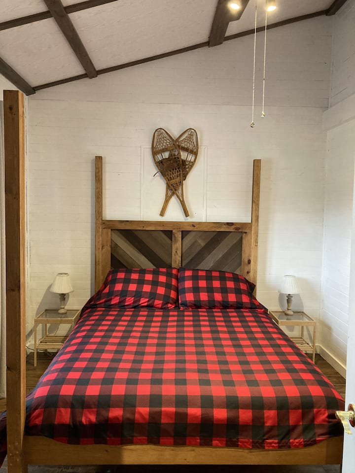 Cama tamaño queen en el dormitorio principal con cómoda y estaciones de carga montadas en la pared. Se proporcionan todas las sábanas 
