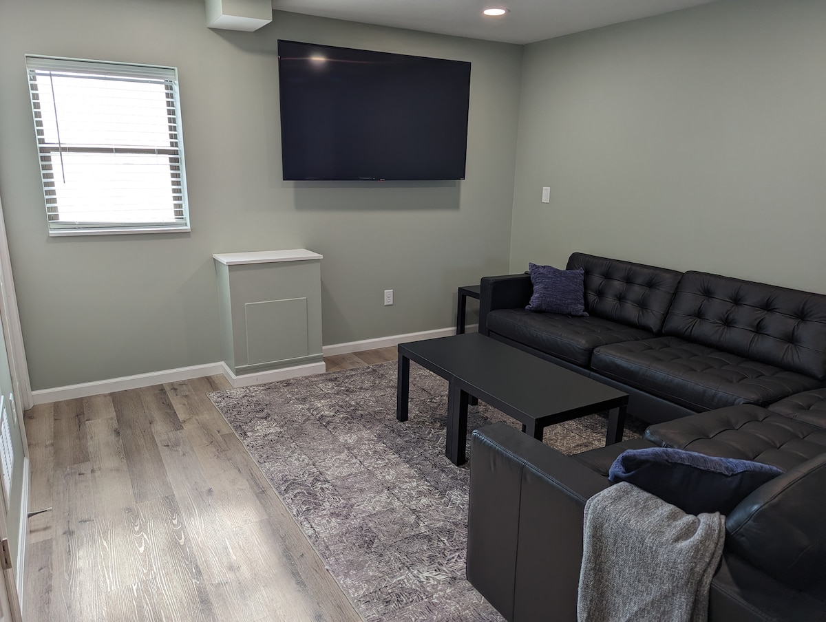 Obývacia izba má 65-palcovú inteligentnú televíziu a pekný gauč.