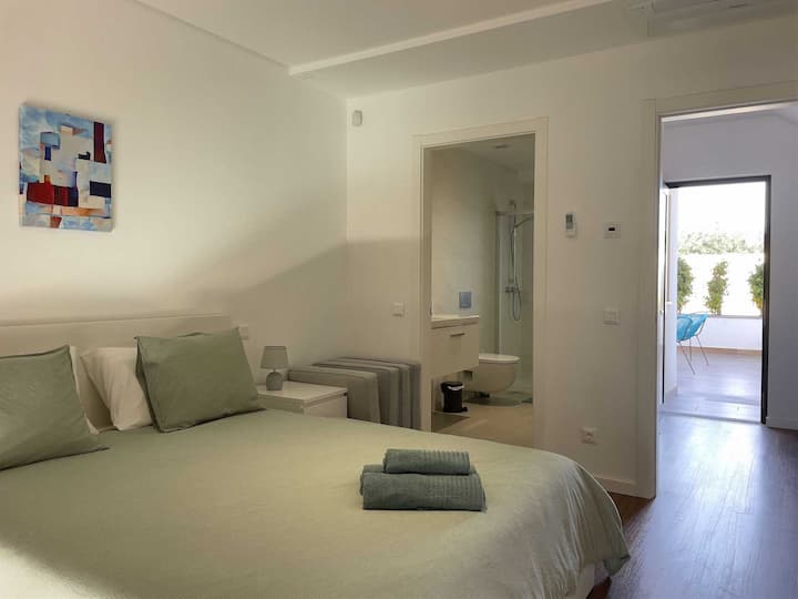 Spálňa 2 s manželskou posteľou Queen, vlastnou kúpeľňou a balkónom.