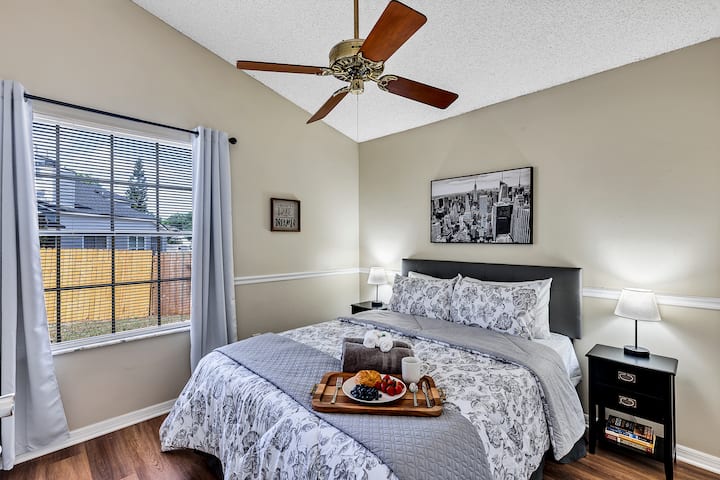 Dormitorio 2: cama tamaño queen con cabecera, ropa de cama cómoda, mesitas de noche negras a juego, ventilador de techo, televisor Roku de 43pulgadas en la pared opuesta (no en la foto) y amplio armario.